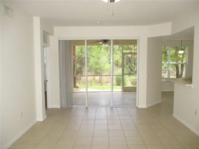 Empty room with plenty of natural light, ceiling fan, and light tile flooring