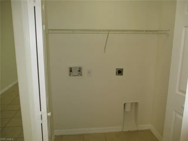 Washroom featuring electric dryer hookup, washer hookup, and light tile floors