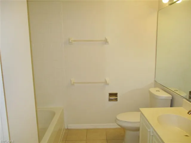Full bathroom featuring tile flooring, washtub / shower combination, vanity, and toilet