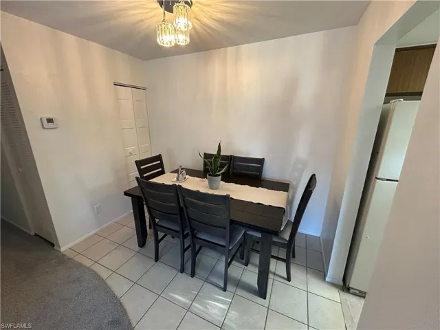 Tiled dining room with a notable chandelier