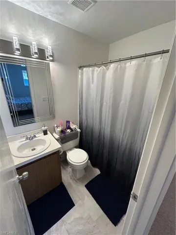 Bathroom with vanity, toilet, and walk in shower