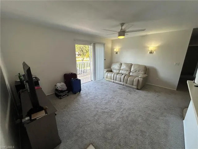 Carpeted living room with ceiling fan