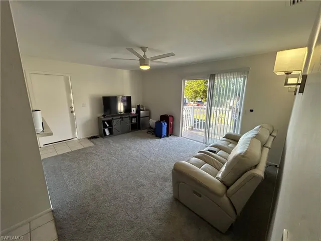 Living room featuring light colored carpet and ceiling fan