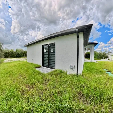 Rear view of house with a yard and stucco siding
