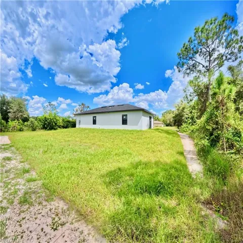 Rear view of property with stucco siding and a yard