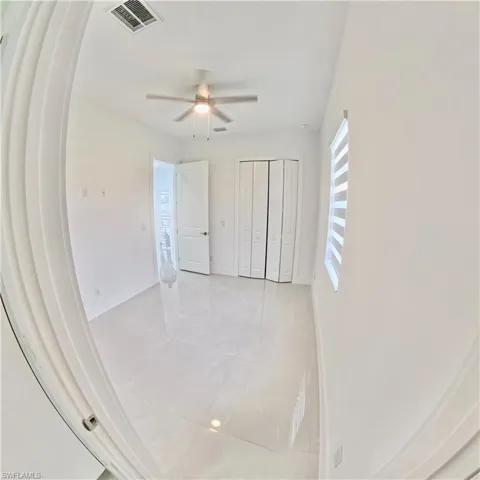 Unfurnished bedroom with tile patterned flooring, a closet, and ceiling fan