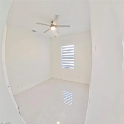 Spare room with light tile patterned flooring and a ceiling fan