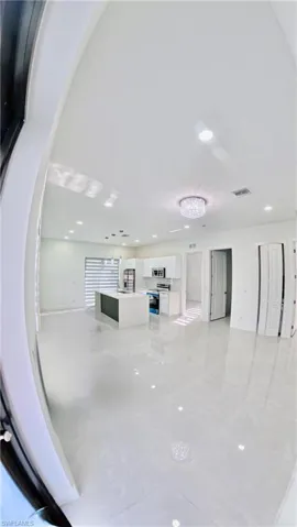 Unfurnished living room featuring recessed lighting and baseboards