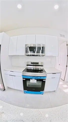 Kitchen featuring appliances with stainless steel finishes, backsplash, white cabinetry, and recessed lighting