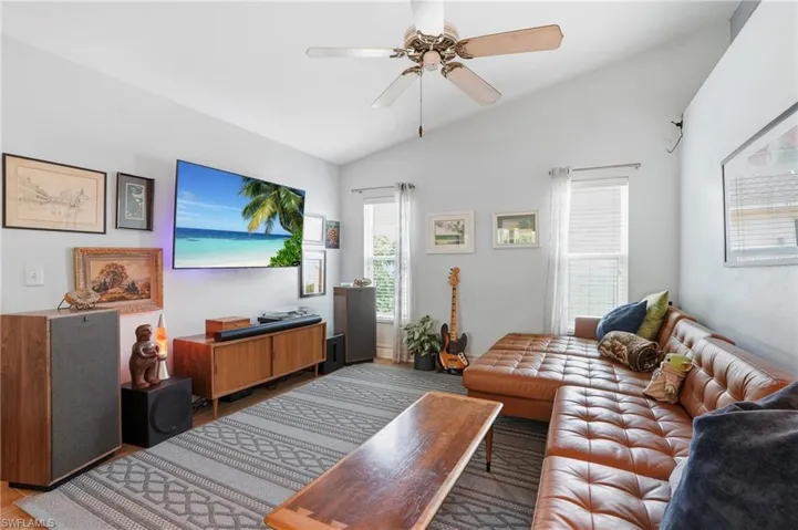 Living area with vaulted ceiling, a ceiling fan, and wood tile floors