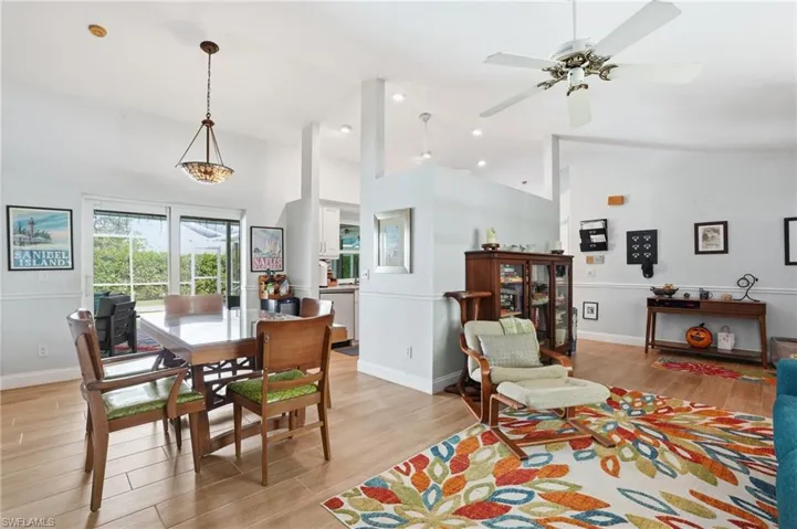 Dining area featuring light wood-type tile flooring, a ceiling fan, vaulted ceiling