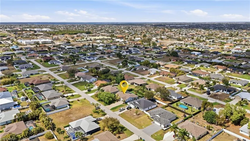 Aerial view of property and surrounding area featuring nearby suburban area