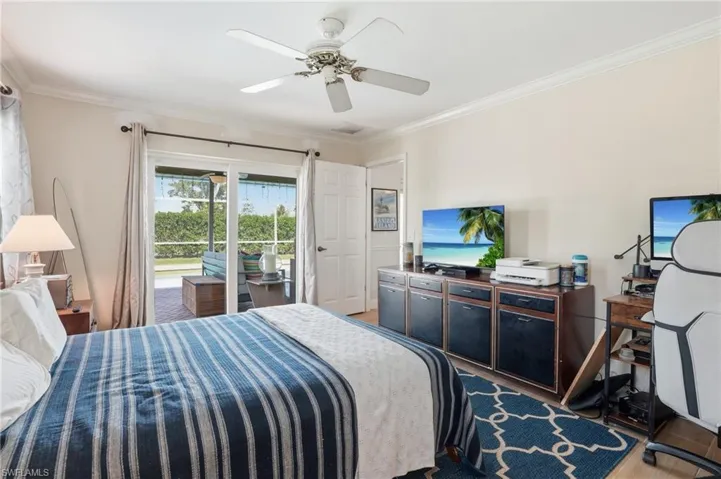 Bedroom with access to outside, a ceiling fan, wood tile floors, and ornamental molding