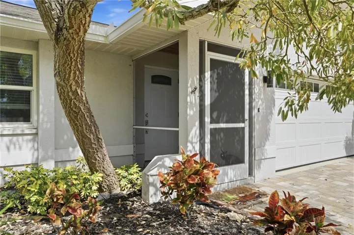 Entrance to property with stucco siding and a garage