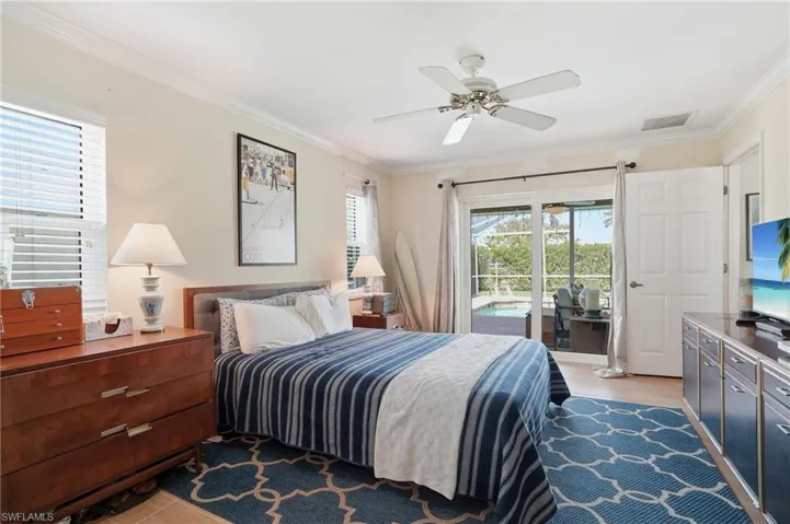 Bedroom featuring ornamental molding, access to exterior, a ceiling fan, and light wood finished floors