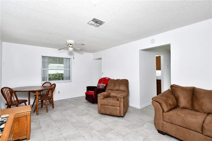 Living area with a ceiling fan and a textured ceiling