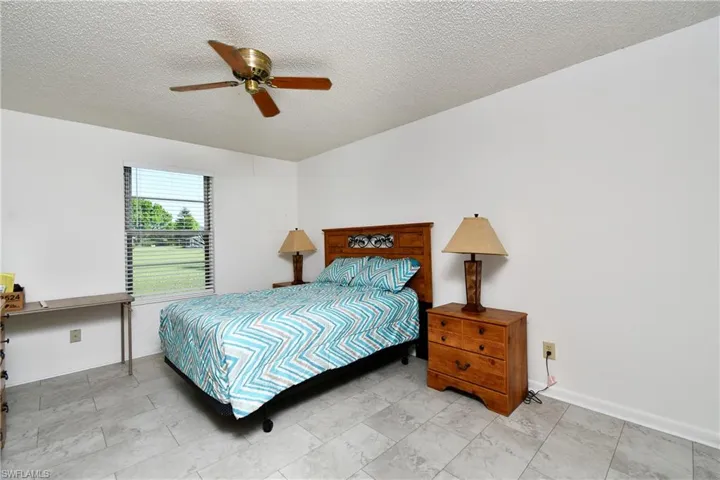 Bedroom featuring a textured ceiling, ceiling fan, and baseboards