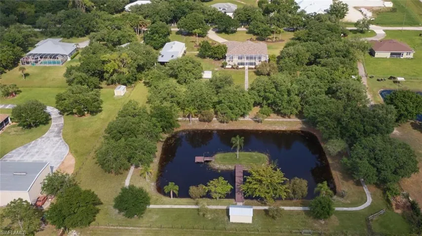 Good view of the lake.  Dock leads to your island and little pier.  You can see your full walking path, both sheds, double barn and great home!  Also shown is distance between neighbors.  That is very nice in itself.  Open Space!