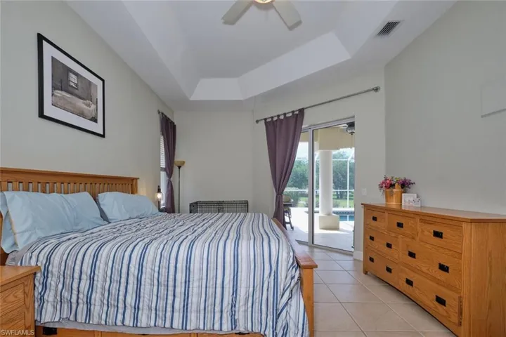 Slider from main bedroom to lanai/pool.  Beautiful tray ceilings complete this LARGE main bedroom.