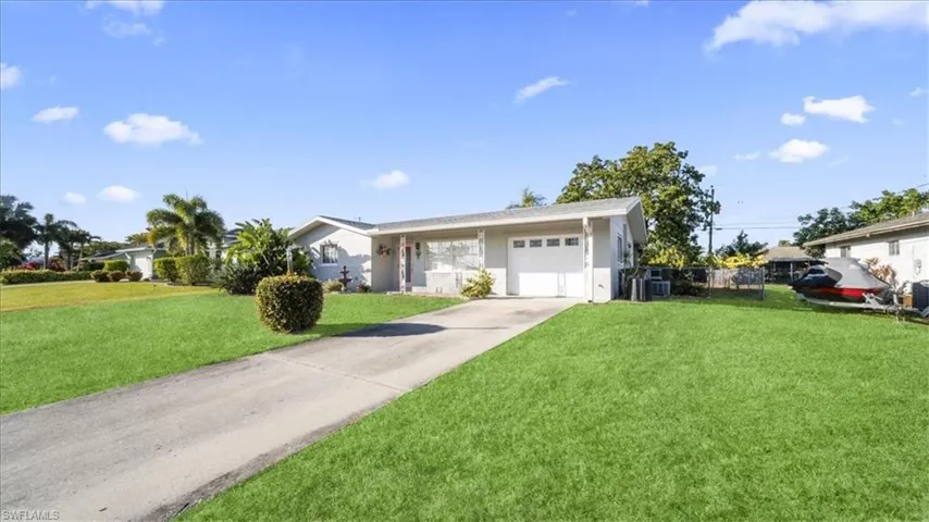 Ranch-style home featuring a garage and concrete driveway