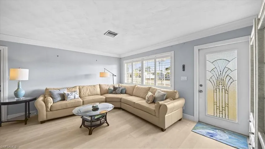 Living area featuring wood finished floors and crown molding