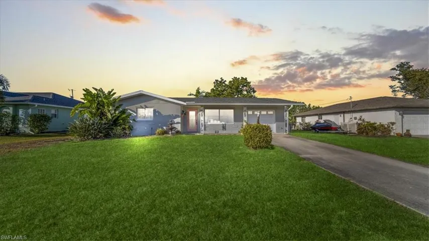 Ranch-style house with a front yard and concrete driveway