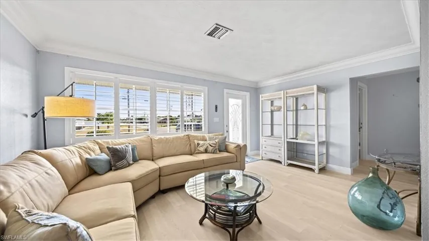 Living room featuring wood finished floors and crown molding