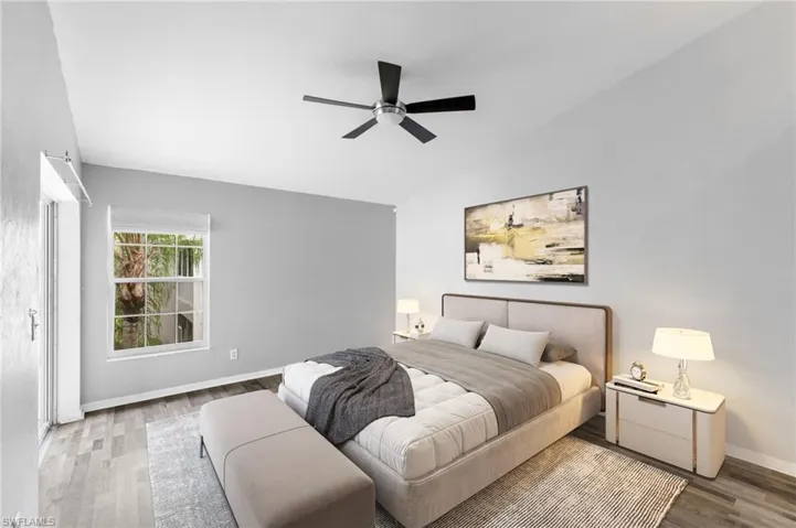 Bedroom with ceiling fan, hardwood / wood-style flooring, and lofted ceiling