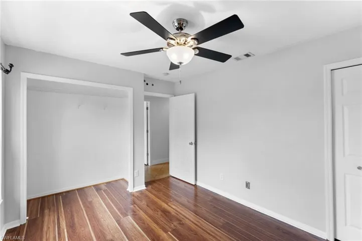 Unfurnished bedroom featuring wood-type flooring and ceiling fan