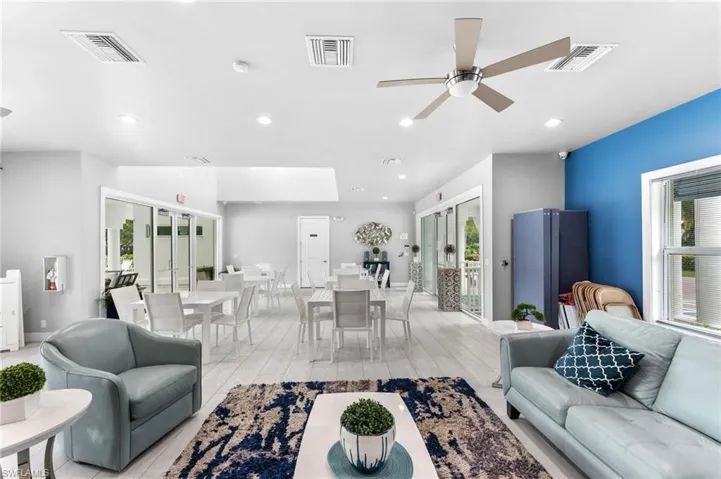 Living room with a healthy amount of sunlight, light hardwood / wood-style floors, french doors, and ceiling fan
