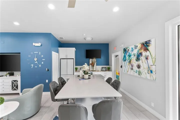 Kitchen with light hardwood / wood-style floors, white cabinets, a breakfast bar area, and a center island