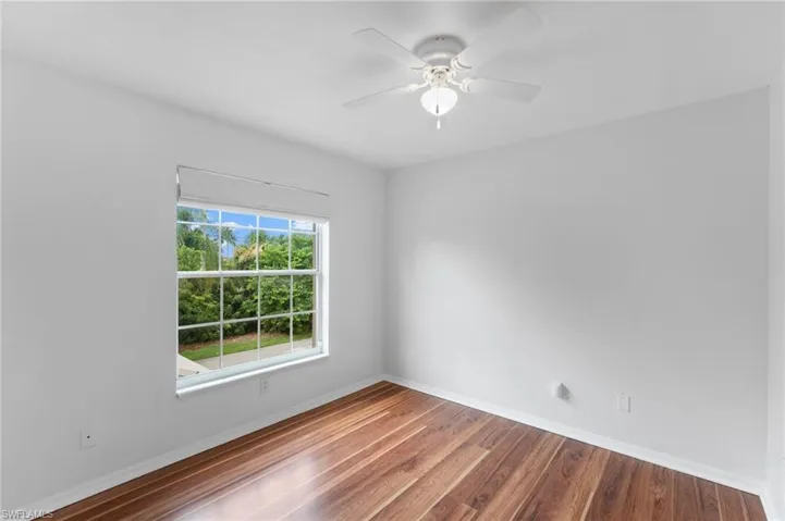 Empty room with hardwood / wood-style flooring and ceiling fan