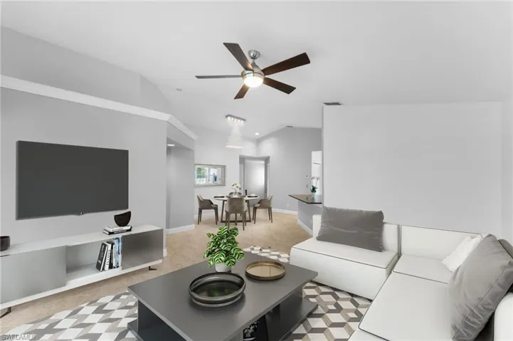 Living room featuring vaulted ceiling and ceiling fan