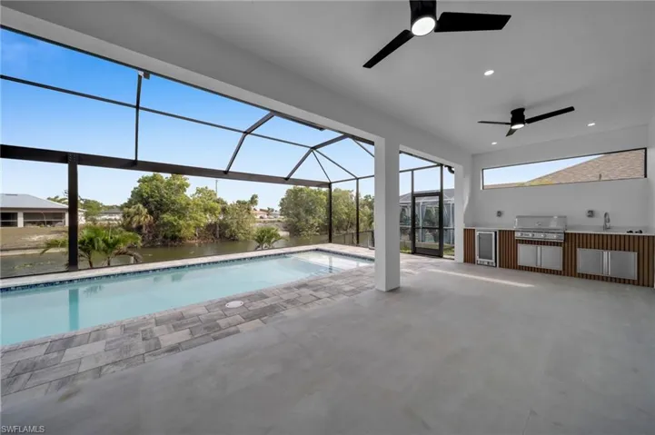 Pool featuring a lanai, a patio area, area for grilling, a grill, and a ceiling fan
