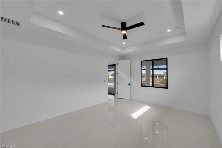 Spare room featuring visible vents, recessed lighting, a raised ceiling, and a ceiling fan