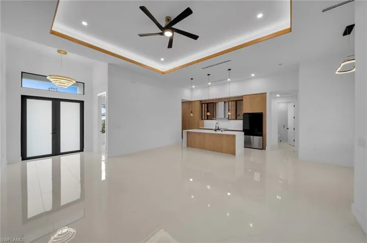 Kitchen featuring brown cabinetry, refrigerator, modern cabinets, and a tray ceiling