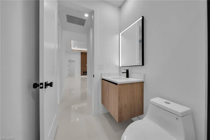 Half bathroom with visible vents, toilet, and vanity