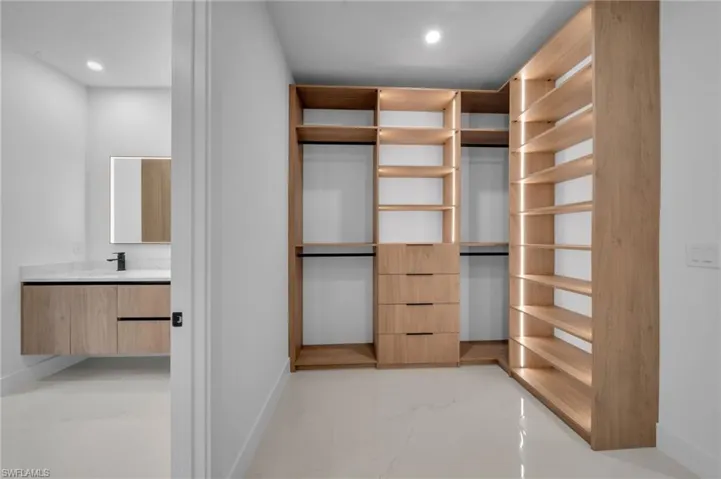 Spacious closet with marble finish floor and a sink