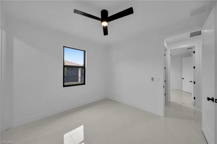 Empty room with visible vents, baseboards, marble finish floor, and ceiling fan