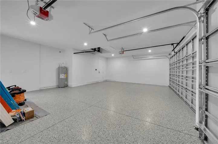 Garage featuring a garage door opener and water heater