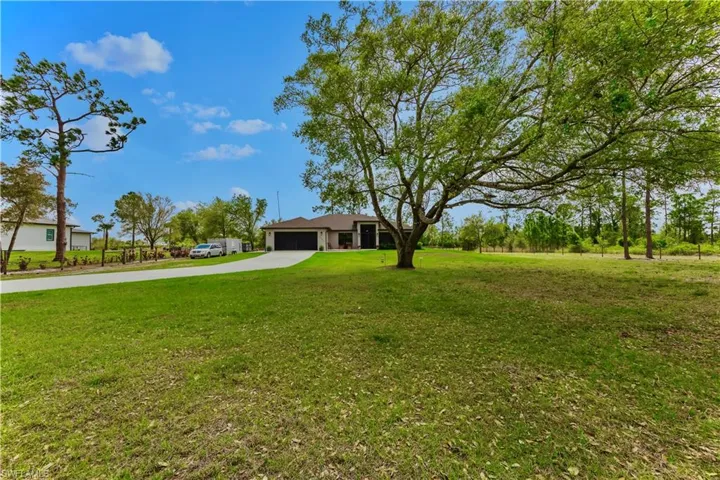 View of yard featuring a garage and driveway