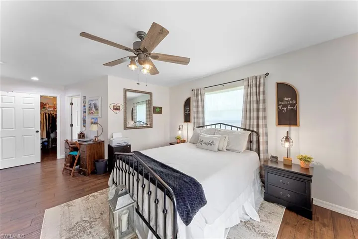 Bedroom with baseboards, a ceiling fan, hardwood / wood-style floors, a walk in closet, and a closet