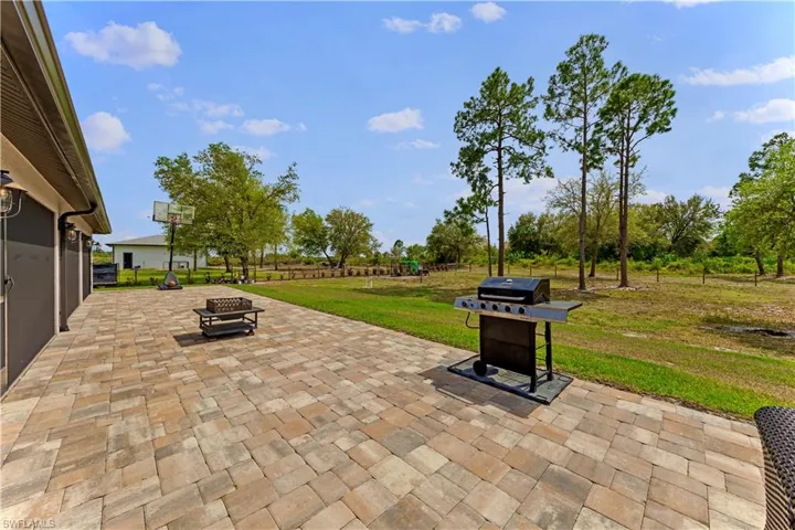 View of patio with a grill and a fire pit