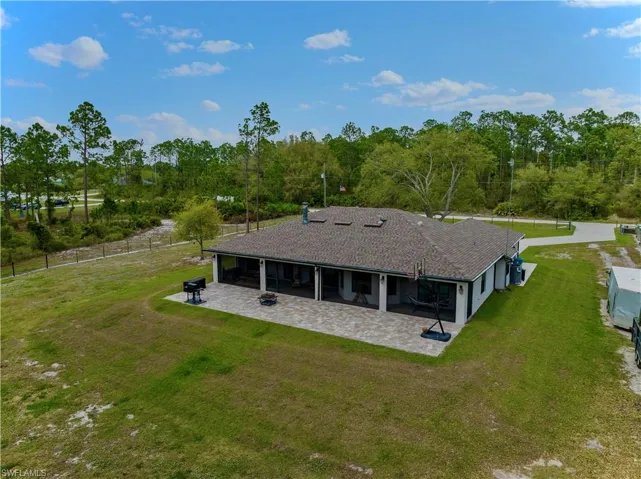 Back of property featuring a patio area, a yard, and a fenced backyard
