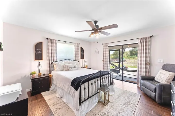 Bedroom with access to exterior, wood-type flooring, and ceiling fan