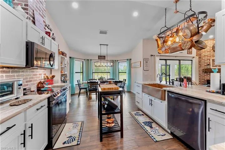 Kitchen featuring a sink, visible vents, white cabinets, appliances with stainless steel finishes, and dark wood-style floors