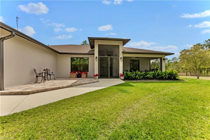 Back of property with a yard, a patio, and stucco siding