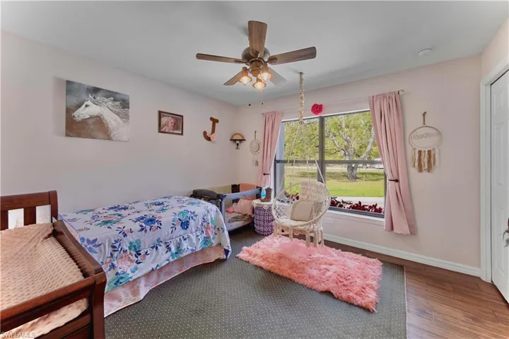Bedroom featuring a ceiling fan, baseboards, and wood finished floors