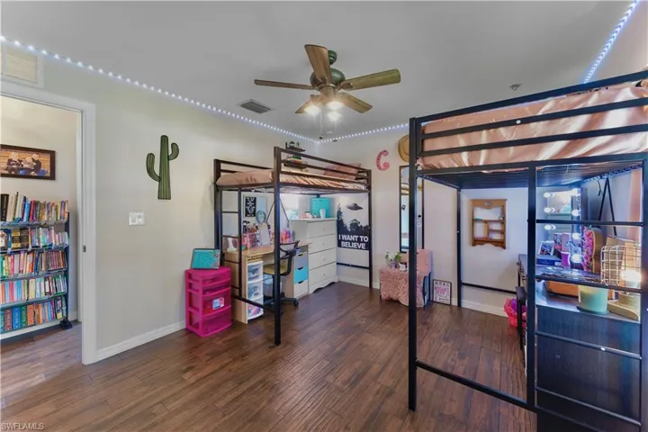 Bedroom featuring baseboards, visible vents, and wood finished floors