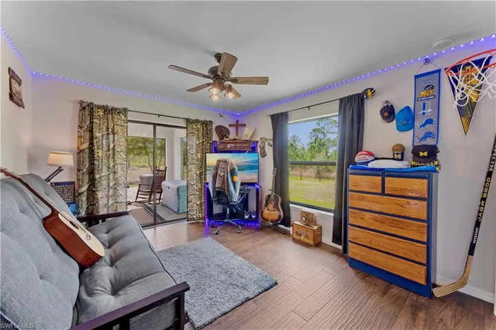 Living room with baseboards, a ceiling fan, and wood finished floors